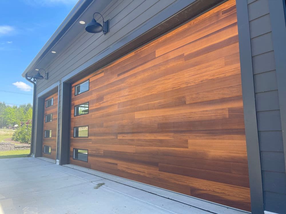 Modern wooden garage doors with sleek design and large windows on a contemporary home.