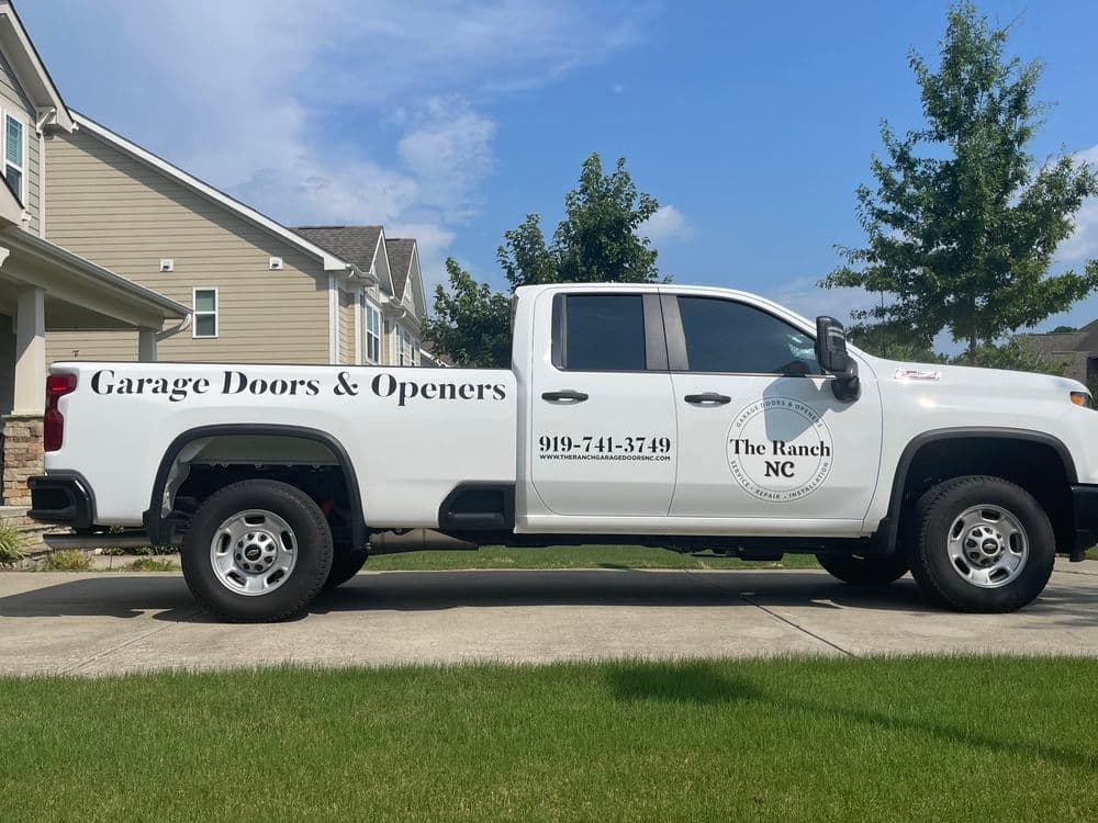 White truck for The Ranch NC, featuring garage doors and openers services contact information.