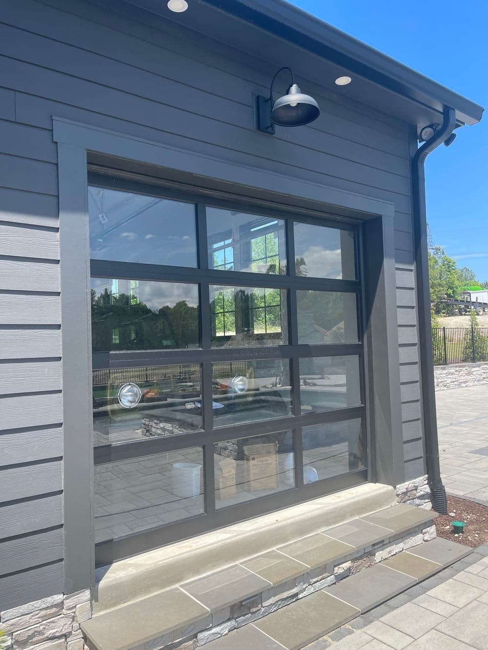 Modern garage door with large windows on a contemporary home exterior, sunny day.